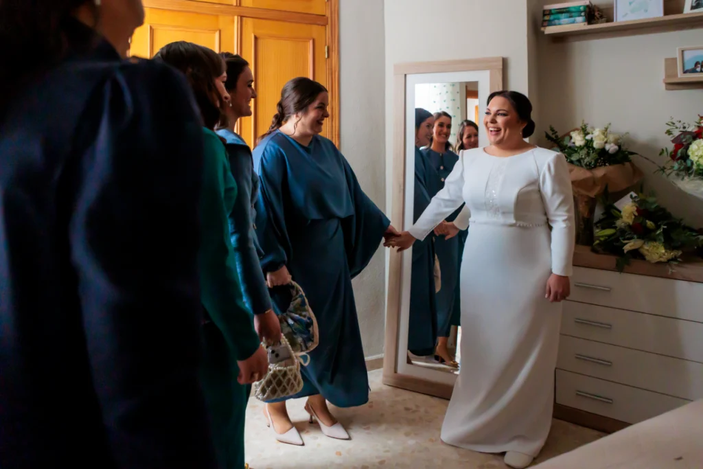 Novia compartiendo un momento con amigas antes de salir hacia la ceremonia.