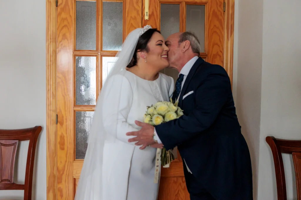 Padre besando a la novia en un momento emotivo durante su boda en Jaén.