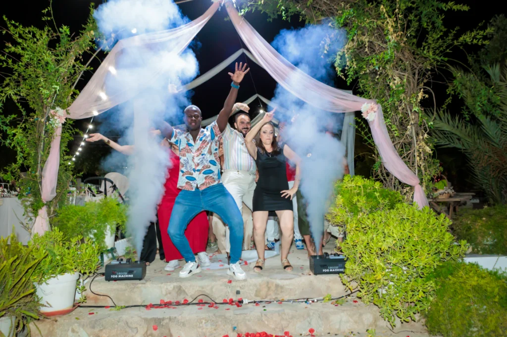 Invitados celebrando durante la fiesta de celebracion nupcial en Jaén con humo de colores