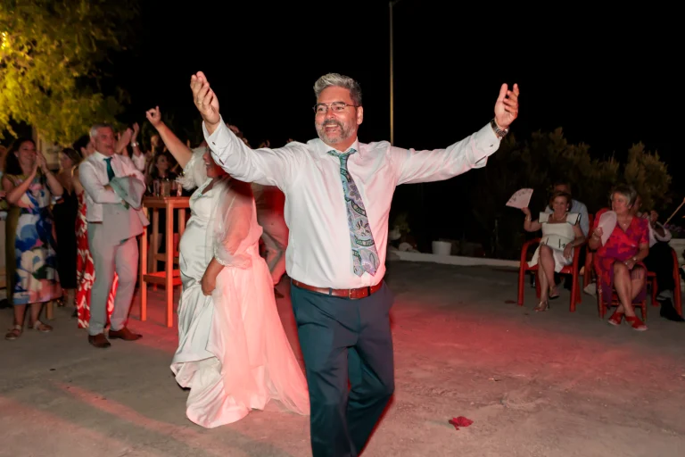Novio entrando con los brazos abiertos durante la fiesta nocturna de boda en Jaén mientras los invitados aplauden.
