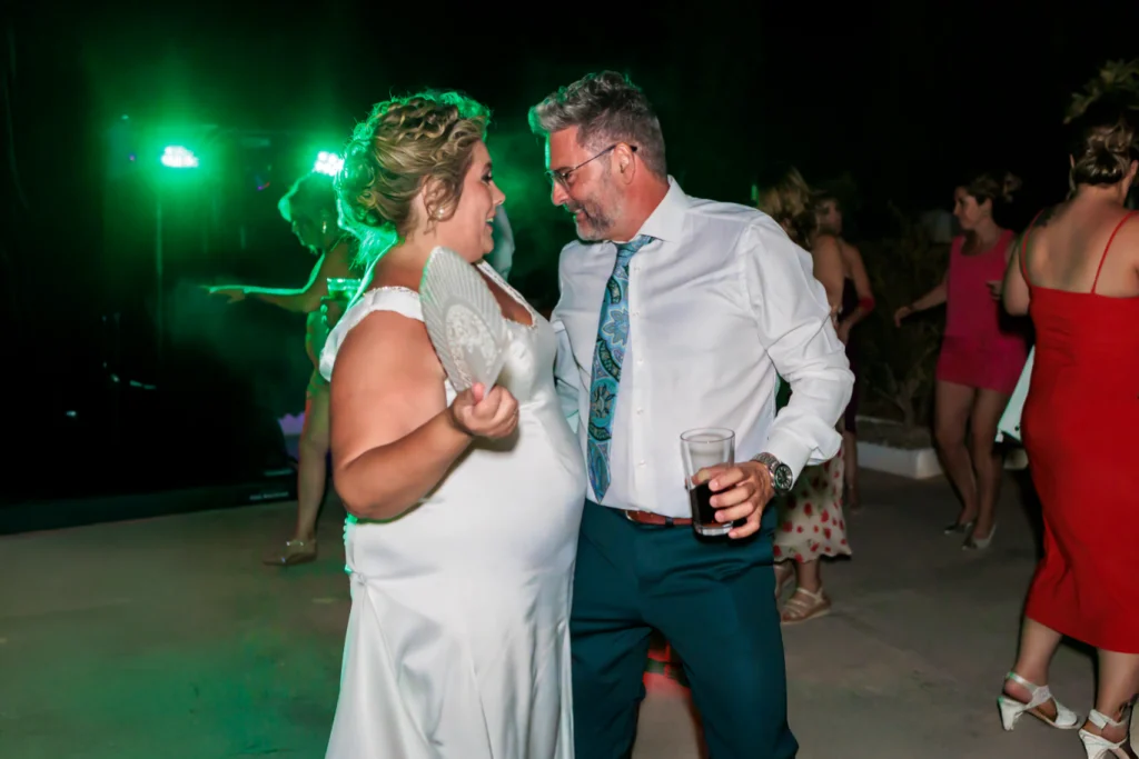 Novios bailando juntos durante la fiesta nocturna de boda en Jaén con iluminación verde y ambiente festivo.
