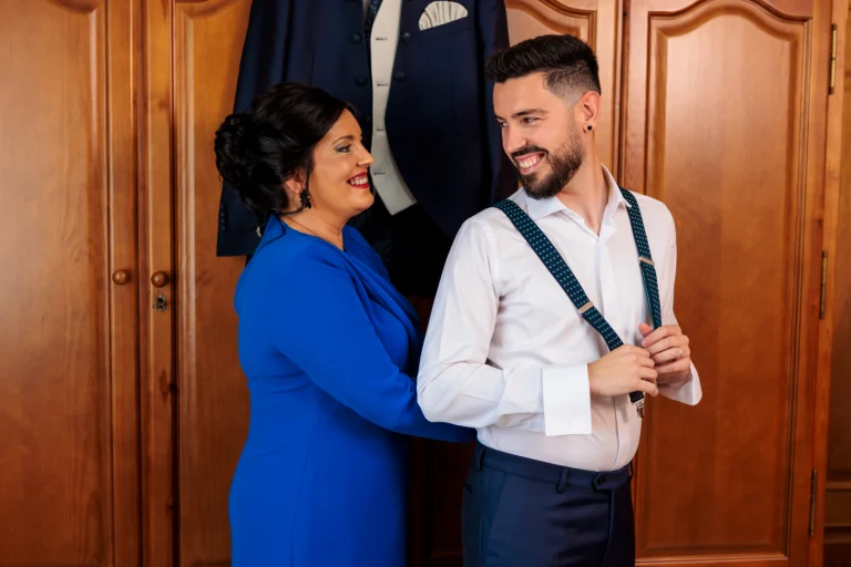 Hermana ayudando al novio a vestirse en preparativos de matrimonio