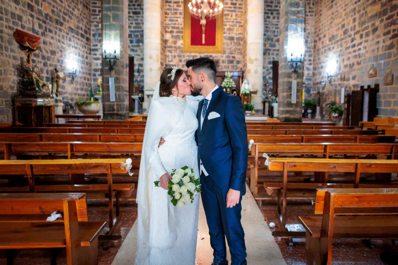 Novios besándose en el interior de la iglesia tras la ceremonia de en Jaén