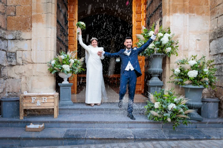 Salida de la ceremonia en Jaén con los novios celebrando entre pétalos y aplausos