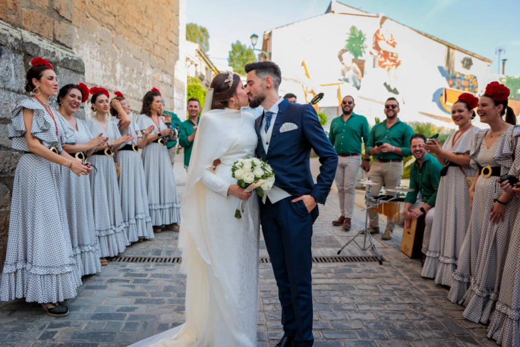Pareja besándose a la salida de la ceremonia en Jaén rodeados de invitados y música en directo