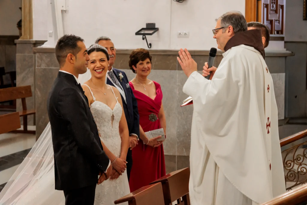 Novios durante la ceremonia religiosa escuchando al sacerdote en su boda en Jaén.