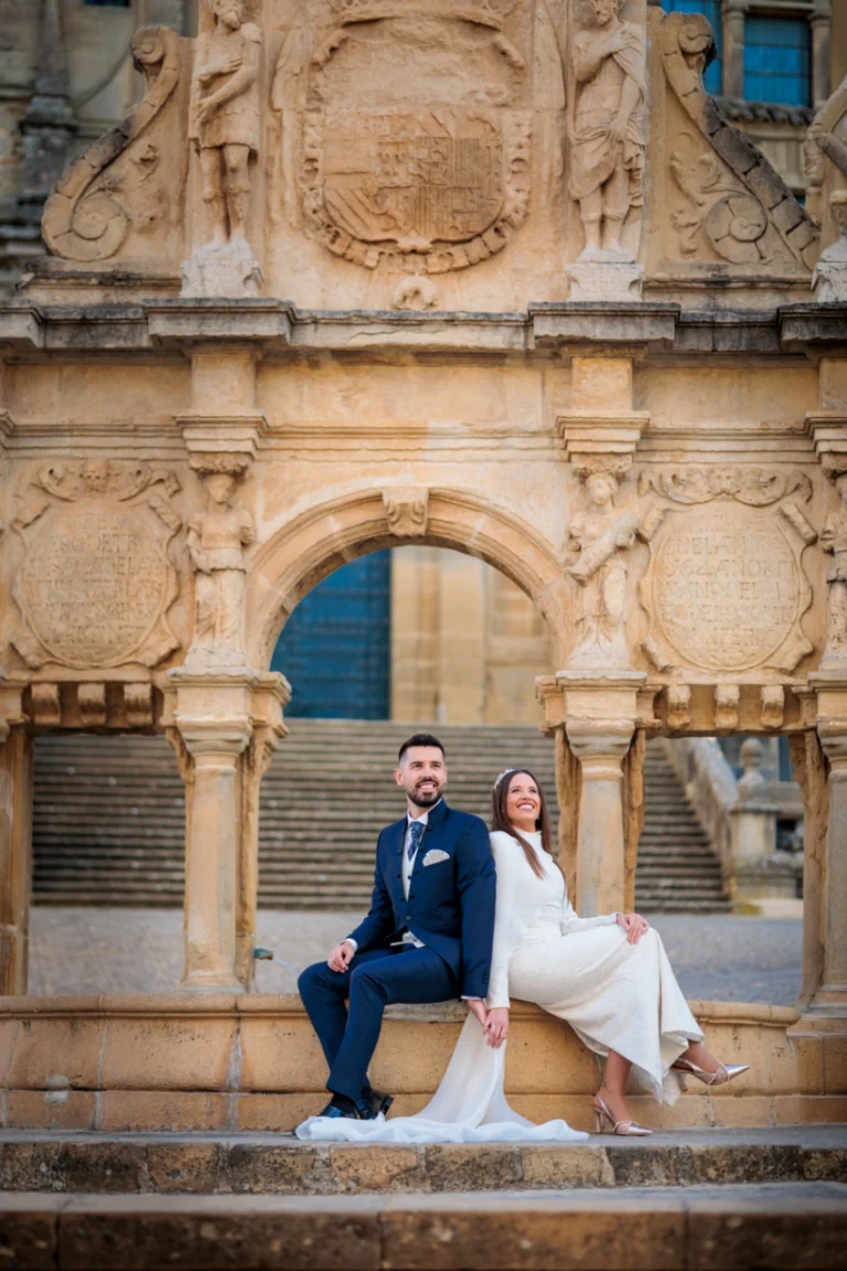 Novios sentados en una fuente histórica de Baeza durante su boda en Jaén