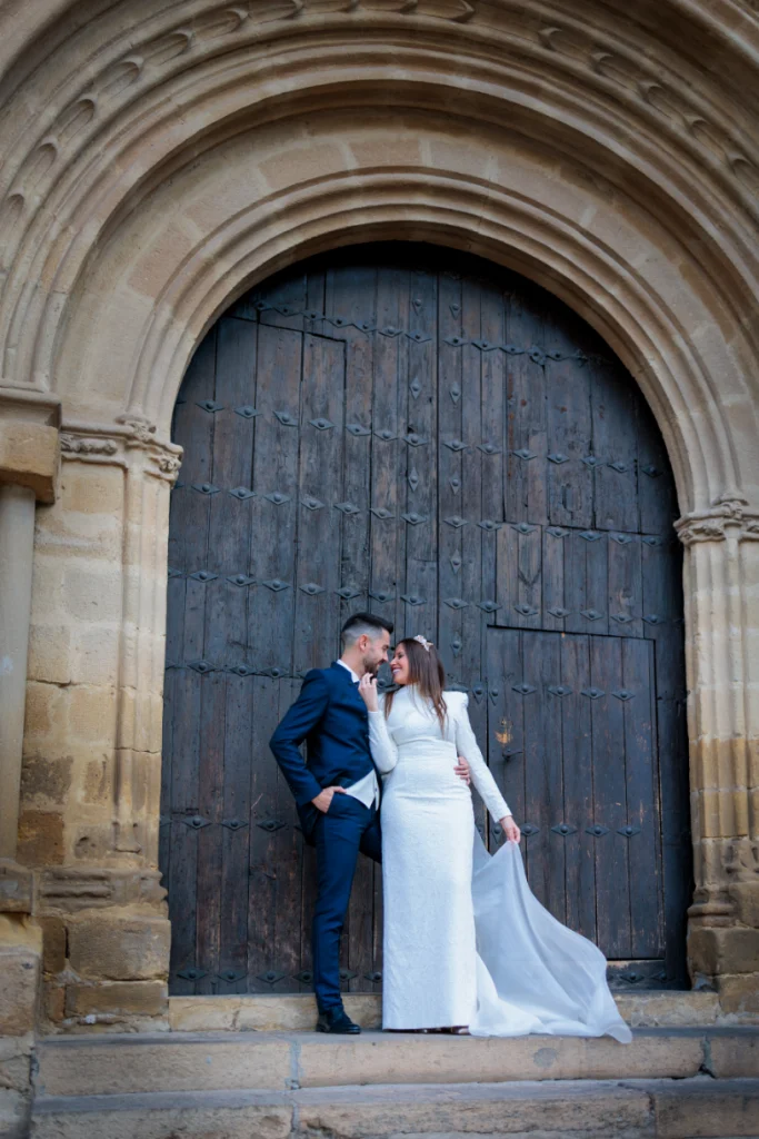 Novios posando frente a una puerta histórica en Baeza durante su boda en Jaén