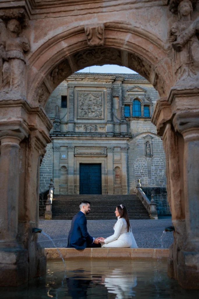Novios sentados frente a la catedral de Baeza durante su postboda en Jaén